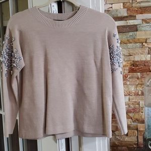 Light sweater with sequences on sleeves